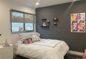 Soft daylight illuminating a girl’s bedroom in Altadena through sheer roller shades, highlighting relaxing and stylish window treatment ideas.